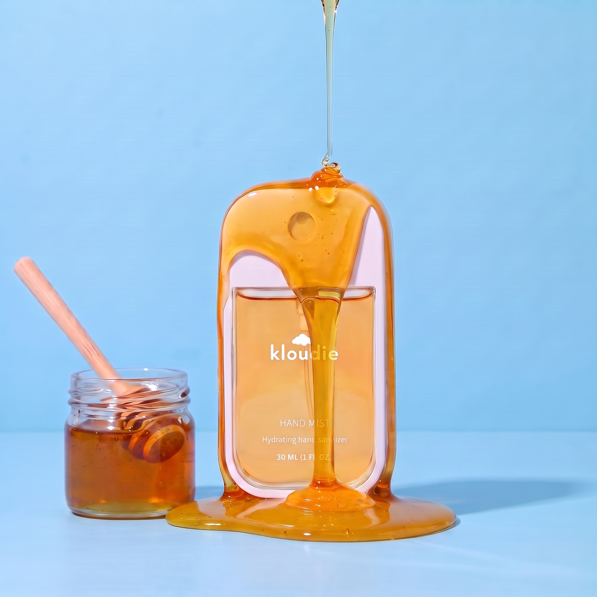 Kloudie Golden Hour hand mist with honey pouring over the bottle